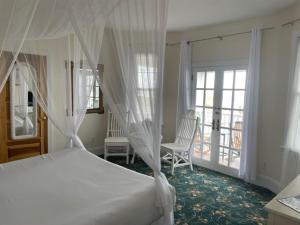 五月岬郡麦康伯酒店 的一间带白色床的卧室和一个阳台