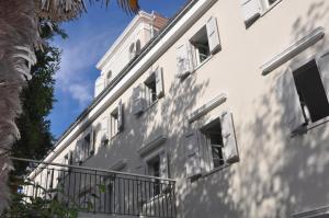 大洛希尼Hotel Villa Elisabeth - Veli Lošinj Health Resort的白色的建筑,设有窗户和阳台