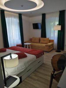 大洛希尼Hotel Villa Elisabeth - Veli Lošinj Health Resort的一间卧室配有一张床和一张沙发