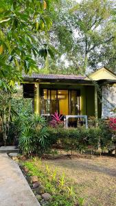 库德岛Baan Bua Cottage SHA EXTRA PLUS B5510的前面有大量植物的黄色房子