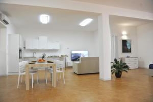 科尔萨诺Salento Mare Daniela - Open Space的厨房以及带桌椅的起居室。
