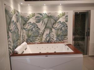 卡塔尼亚Terra Mia Suite的带浴缸的浴室和热带壁纸