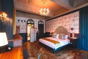 里昂巴亚德贝尔库尔酒店的一间卧室设有一张大床和砖墙