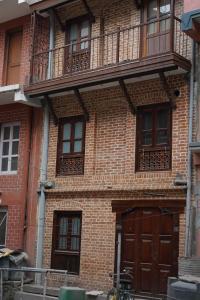 加德满都Studio Apartment at UNESCO Heritage Site的砖砌建筑,设有木门和阳台