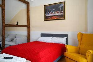 耶拿FULL HOUSE Premium Apartments Jena Holzmarkt的一间卧室配有红色的床和黄色的椅子