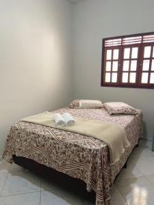 巴纳内拉斯Casa agradável no centro的一间卧室配有一张床,上面有两条毛巾