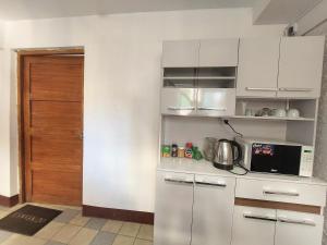 库斯科Las Dalias的厨房配有白色橱柜和门