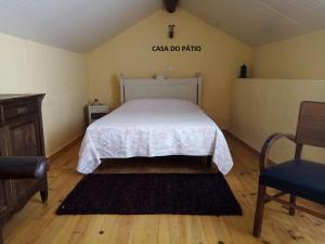 卡什塔涅拉德佩拉Casa do Pátio e Casa da Serra的卧室配有一张床,墙上有标志