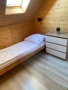 卡尔维亚Morza szum的木制客房的一张床位,设有窗户