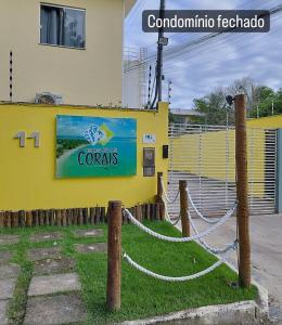 Coroa VermelhaPraia dos Corais - Bahia的黄色的建筑,上面有读珊瑚的标志
