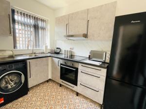 诺丁汉Lovely 2 bed Apartment, Arnold Town centre.的厨房配有黑色冰箱和洗碗机。