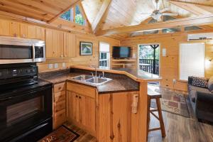 MonetaHalesford Harbour Resort - Smith Mountain Lake的小屋内的厨房设有水槽和炉灶