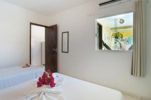 嘎林海斯港Pousada Aconchego do Maraca的白色的客房配有两张床和镜子
