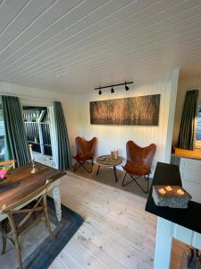 VeksøHyggelig sommerhus. med udsigt, til vand fra senge的客厅配有椅子,铺有木地板