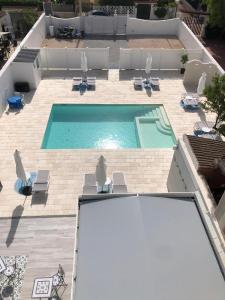普尔萨诺B&B Alto Salento - Pool and Sun的享有带躺椅的游泳池的顶部景致
