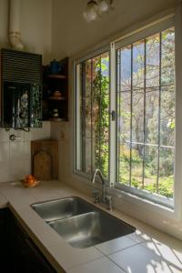 卡塔马卡Casa de campo La Brea的带水槽的厨房和2扇窗户