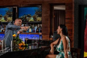 维洛海滩德埃斯特海岸海滩温泉度假酒店的男人在酒吧为女人喝一杯酒