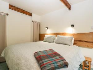 LydbrookTinmans Cottage的一间卧室配有一张床铺,床上有毯子