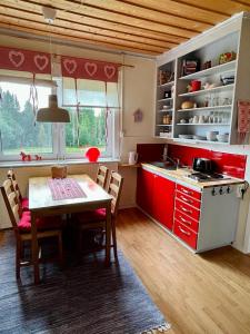 吕克瑟勒,,Björklunda" cozy apartment in swedish lapland的厨房配有红色橱柜和桌椅