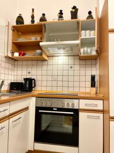 维也纳Ruhiges Dachgeschoß CityApartment im Zentrum Wiens的厨房配有白色橱柜和黑烤箱。