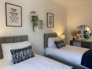 Kenfig HillThe Retreats 2 Kenfig Hill Pet Friendly 2 Bedroom Flat with King Size bed twin beds and sofa bed sleeps up to 5 people的卧室内两张并排的床