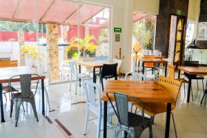 韦拉克鲁斯VF Villa Florencia Hotel的餐厅设有木桌、椅子和窗户。