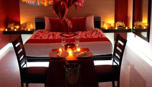 El AlcanforAuto Hotel Deluxe的一间卧室配有一张床和一张带蜡烛的桌子