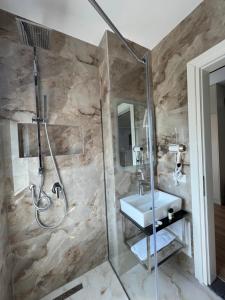 圣金Hotel LEON - Beach Front的带淋浴和盥洗盆的浴室