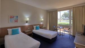 天鹅山天鹅山度假酒店的酒店客房设有两张床和一张桌子。