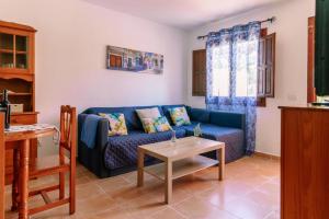 洛思坎加约斯Starfish playa的客厅配有蓝色的沙发和桌子