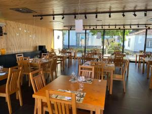 卡佩拉什索拉孔迪酒店的餐厅设有木桌、椅子和窗户。
