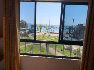 帕拉卡斯Hostal El Amigo的酒店的客房设有一个享有海景的窗户。