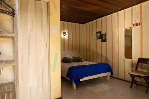 蜜岛Pousada Recanto das Cores的一间卧室配有一张带蓝色毯子的床