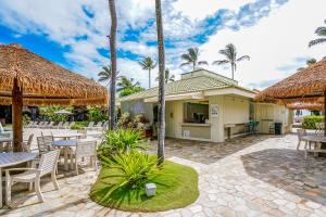 利胡埃Kauai Beach Villas E5的一个带桌椅的庭院,棕榈树