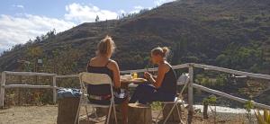 瓦拉斯Ecolodge Casa del Montañista的坐在山前桌子上的两名妇女
