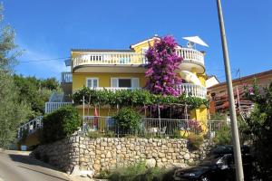 密德维亚Apartments with a parking space Medveja, Opatija - 7721的黄色房子的一侧有鲜花