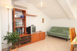 密德维亚Apartments with a parking space Medveja, Opatija - 7721的客厅配有电视和绿色沙发。
