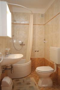 密德维亚Apartments with a parking space Medveja, Opatija - 7721的浴室配有卫生间、盥洗盆和浴缸。