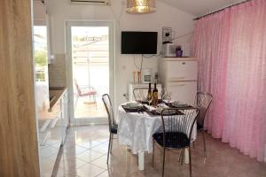 拉维尼Apartments with a parking space Ravni, Labin - 7674的一间带桌子和粉红色窗帘的用餐室