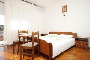 木洛希尼Apartment Mali Losinj 7991b的卧室配有一张床和一张桌子及椅子
