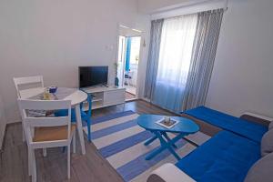 大洛希尼Apartments by the sea Veli Losinj, Losinj - 7959的客厅配有沙发和带蓝色凳子的桌子