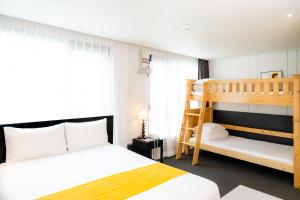 西归浦市Seogwipo Hills Hotel的一间卧室配有一张双层床和梯子