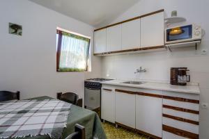 康斯基Apartments by the sea Artatore, Losinj - 7934的厨房配有白色橱柜、水槽和桌子