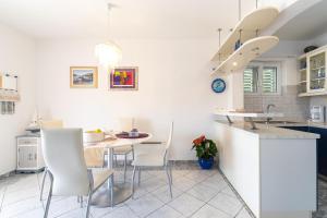 尼亚卢卡Apartments by the sea Cove Gradina, Korcula - 9273的厨房配有白色的椅子和桌子