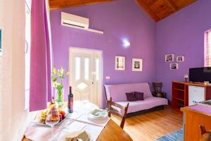 拉茨斯切Apartments by the sea Kneza, Korcula - 9168的紫色的客厅配有桌子和沙发