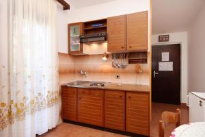 普利兹巴Apartments by the sea Prizba, Korcula - 9227的一个带木制橱柜和水槽的厨房