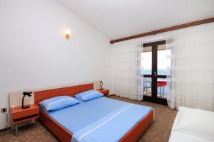 普利兹巴Apartments by the sea Prizba, Korcula - 9227的一间卧室设有一张床和一个大窗户