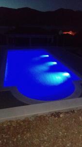 拉茨斯切Seaside apartments with a swimming pool Kneza, Korcula - 9269的夜间蓝色海水游泳池