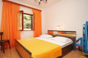 布拉托Seaside holiday house Crnja Luka, Korcula - 9289的一间卧室配有床和橙色窗帘的窗户