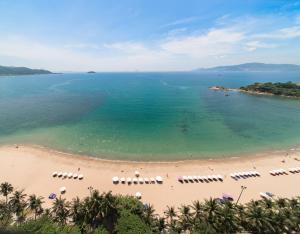 芽庄Navada Beach Hotel的享有海滩的空中景致,配有椅子和遮阳伞